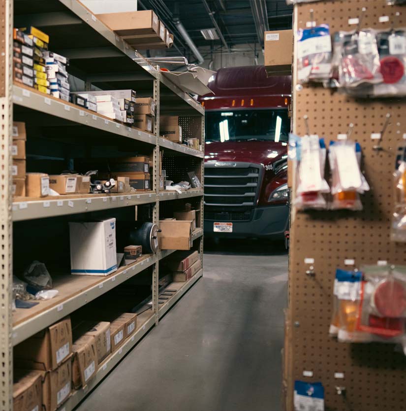 truck part shelf with semi parked behind it
